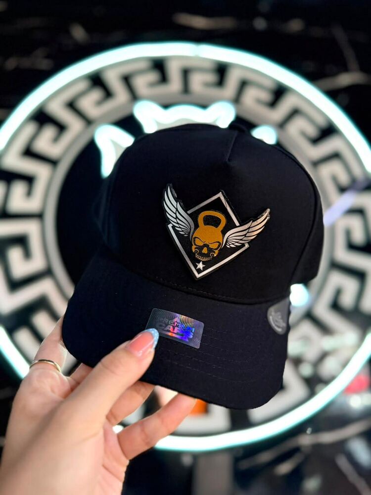 Gorra negra con parche bordado de escudo con alas